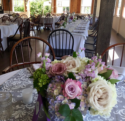 Pink floral arrangements set on gray and white linens