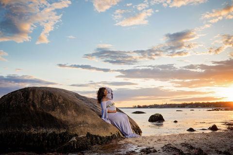 maternity shoot on beach sitting on rock