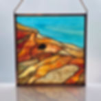 Stained glass window panel of Yellowstone thermal springs with a copper foil overlay buffalo.