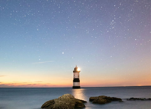 lighthouse at night against the starry sky