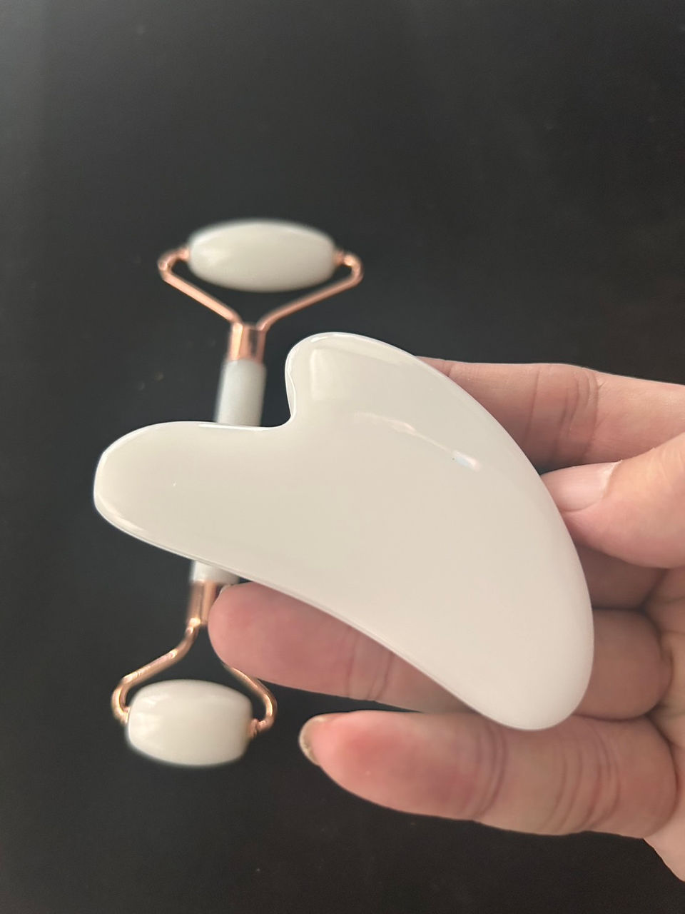 ภาพอุปกรณ์ทั้งชุดวางเรียงบนพื้นดำ ลูกกลิ้งและ Gua Sha