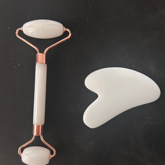 ภาพถ่ายชุดลูกกลิ้งหินและ Gua Sha แบบชัดเจนภายในกล่องพลาสติก