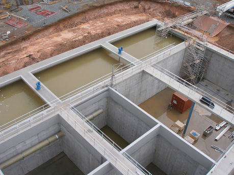 Aerial view of a water treatment plant under construction with concrete basins.