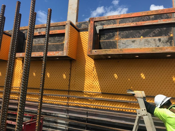 Construction site with formwork ready for concrete, worker present.