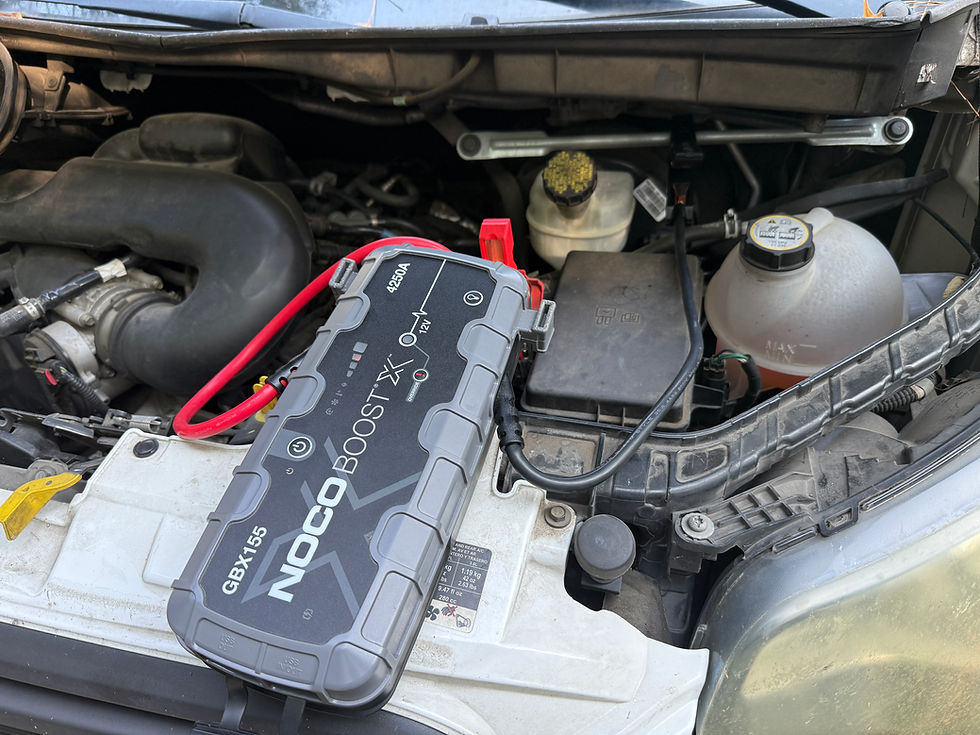 Portable quick battery jump start device on a car engine.