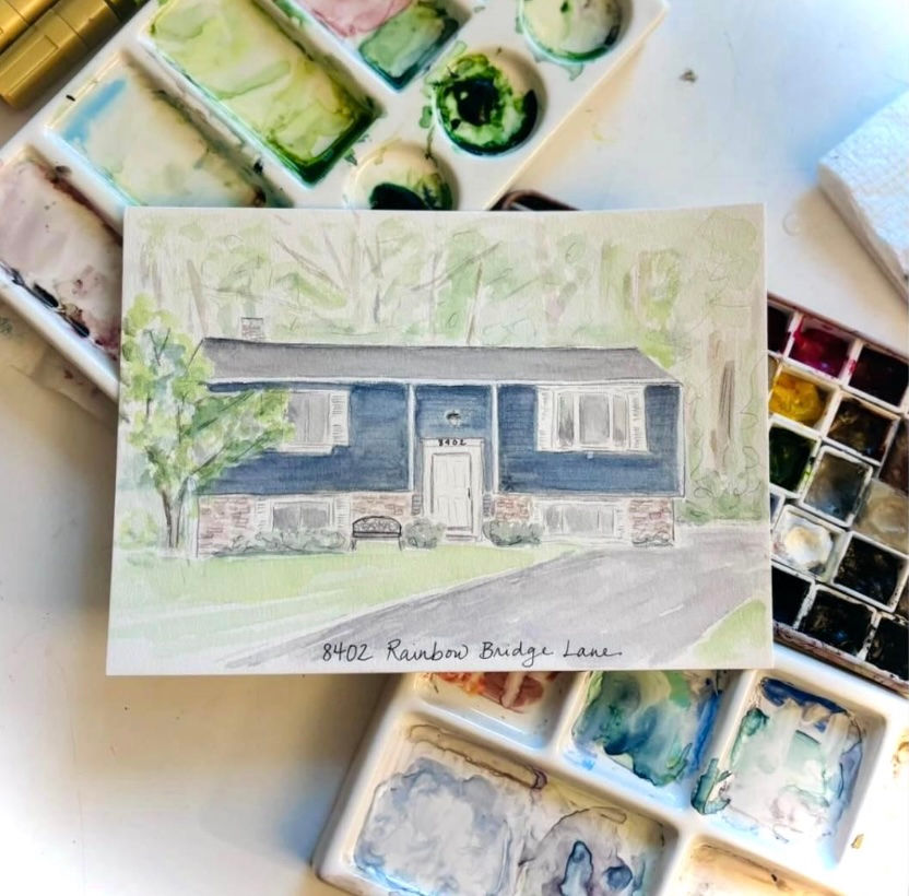Thumbnail: A watercolor painting of a navy blue home resting on a watercolor paint palette.