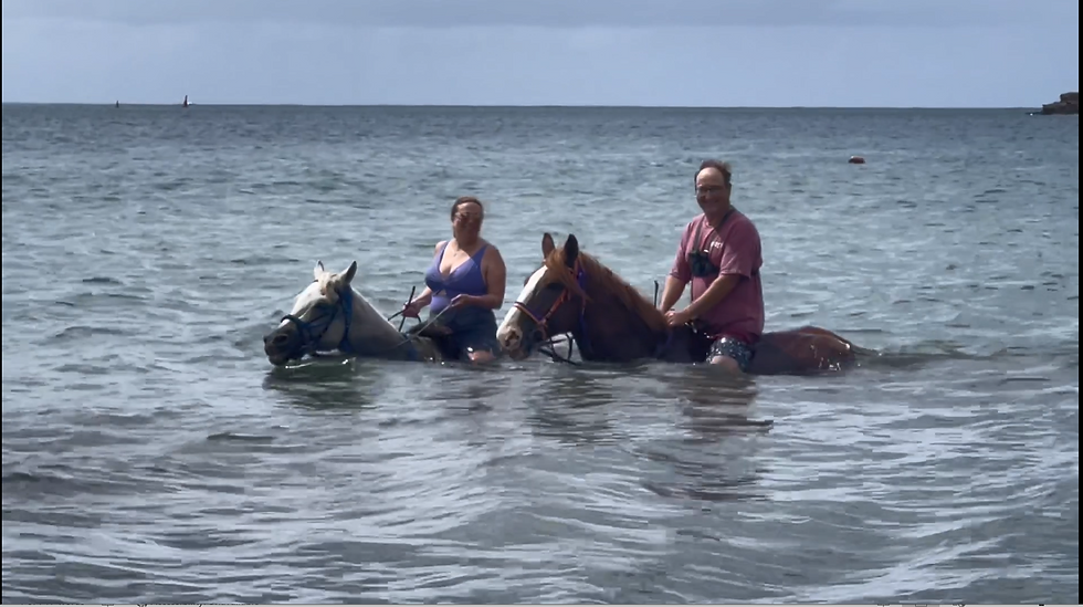 Two people riding horses in the water