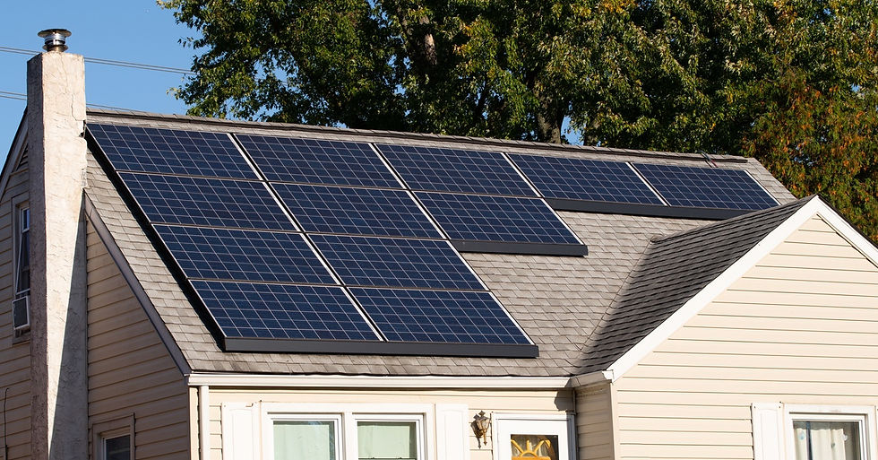 A house with a tall roof, partially covered by solar panels. The house also has a chimney at the end of the roof.