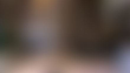 A large, luxury hotel lobby features classic-style chandeliers and velvet ropes near its front desk.