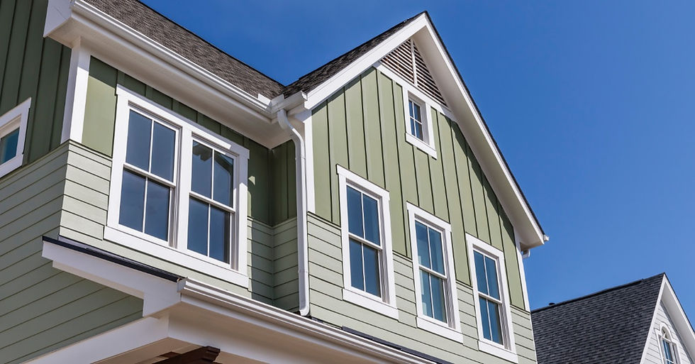 The second floor of a new home with multiple windows. The roof is sloped, and the sky behind the house is clear.
