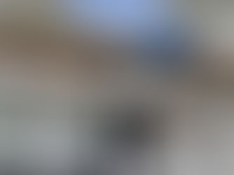 A residential house with major damage to the roof. Part of the gutter has fallen down, revealing the wood underneath.