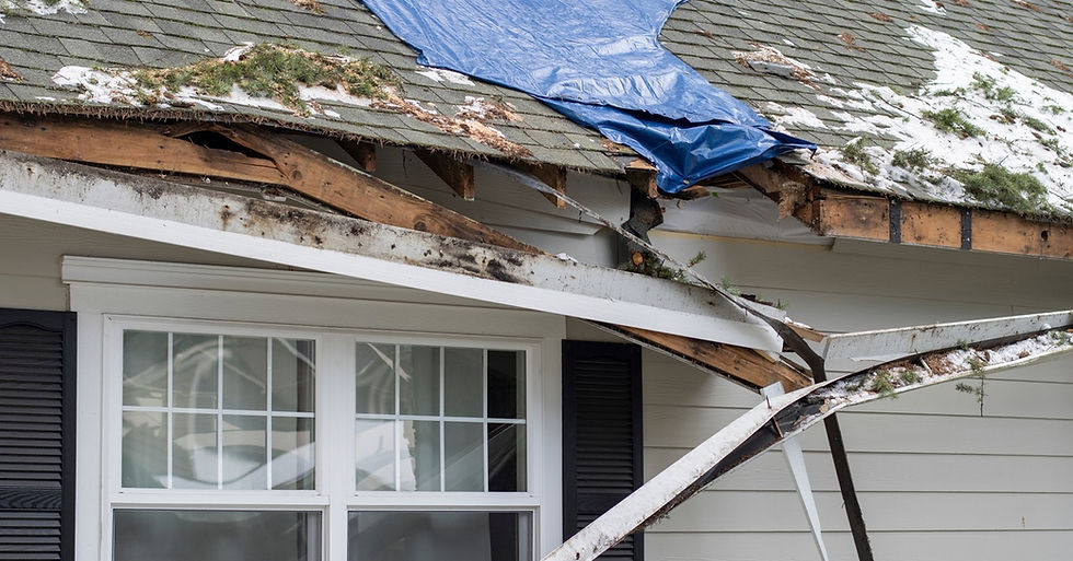 A residential house with major damage to the roof. Part of the gutter has fallen down, revealing the wood underneath.