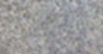 Gray crushed gravel stones with sharp, angular edges form a uniform layer across a flat surface.