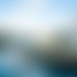 A two-story home facing a canal at sunset, with a small boat lifted next to a dock. Other homes line the opposite shore.