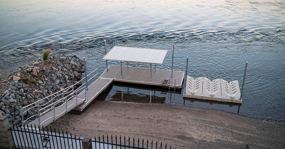 A connected floating dock and PWC platform extend from a rocky shoreline into open water near a covered dock section.