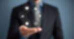 A man in a black and blue suit extending his hand, with hexagons above it displaying images like a lightbulb and a computer.