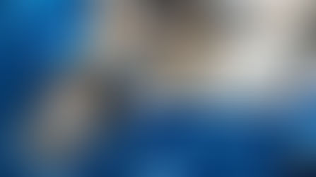 A close-up view shows that a blue gearbox is partially open, exposing the metal gears and parts inside.