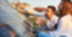 A man pointing to something while his wife and son look. They are all sitting in front of solar panels.