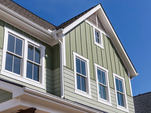 A new home with green siding and high-quality windows. There are five windows on the second floor of the house.