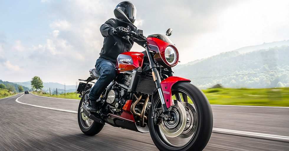 Stylish red sport motorcycle cruising along an open country road, blending classic design elements with modern engineering, performance, and everyday rideability.