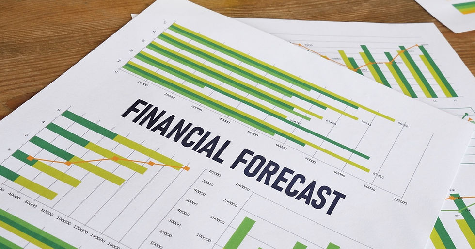 Two pieces of paper sitting on a table with FINANCIAL FORECAST written on the top piece next to multiple bar graphs.