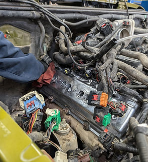 Engine being installed into a vehicle engine bay.