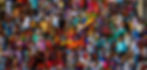 Crowd of people sitting outdoors, holding colorful umbrellas and cloths for shade. Vibrant attire, lively atmosphere, sunny day.