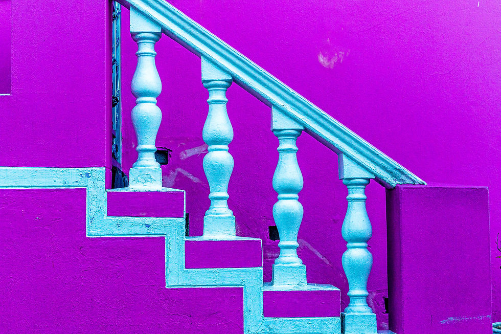 Bright purple wall with blue staircase and ornate balusters. No text. The vibrant colors create a bold, artistic mood.