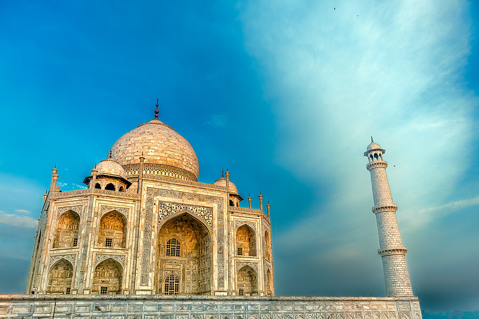 Taj Mahal under a vibrant blue sky, showcasing its ornate white marble dome and minaret, exuding serenity and grandeur.