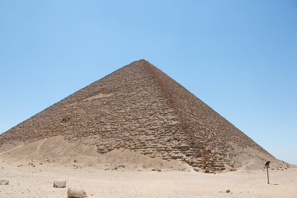 Stone pyramid under a clear blue sky, set in a sandy desert landscape, emanating a sense of ancient grandeur and mystery.