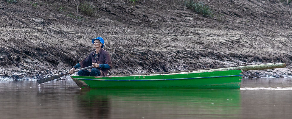 A man paddles his small boat down the Kinabatangan River