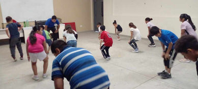 Imagen de alumnos realizando un dinámica dentro de un salón de clases de baile.