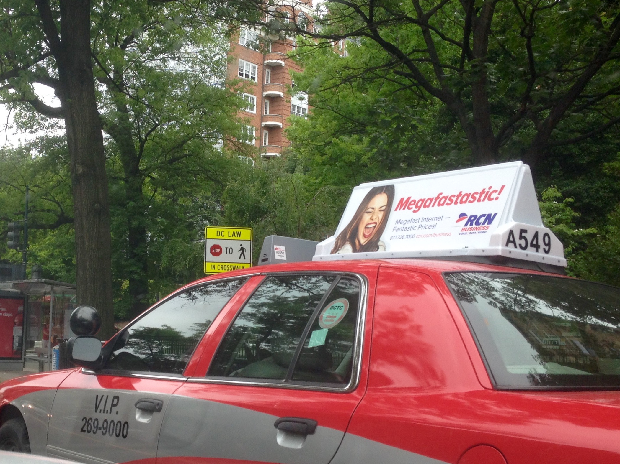 Red taxi with a digital rooftop ad