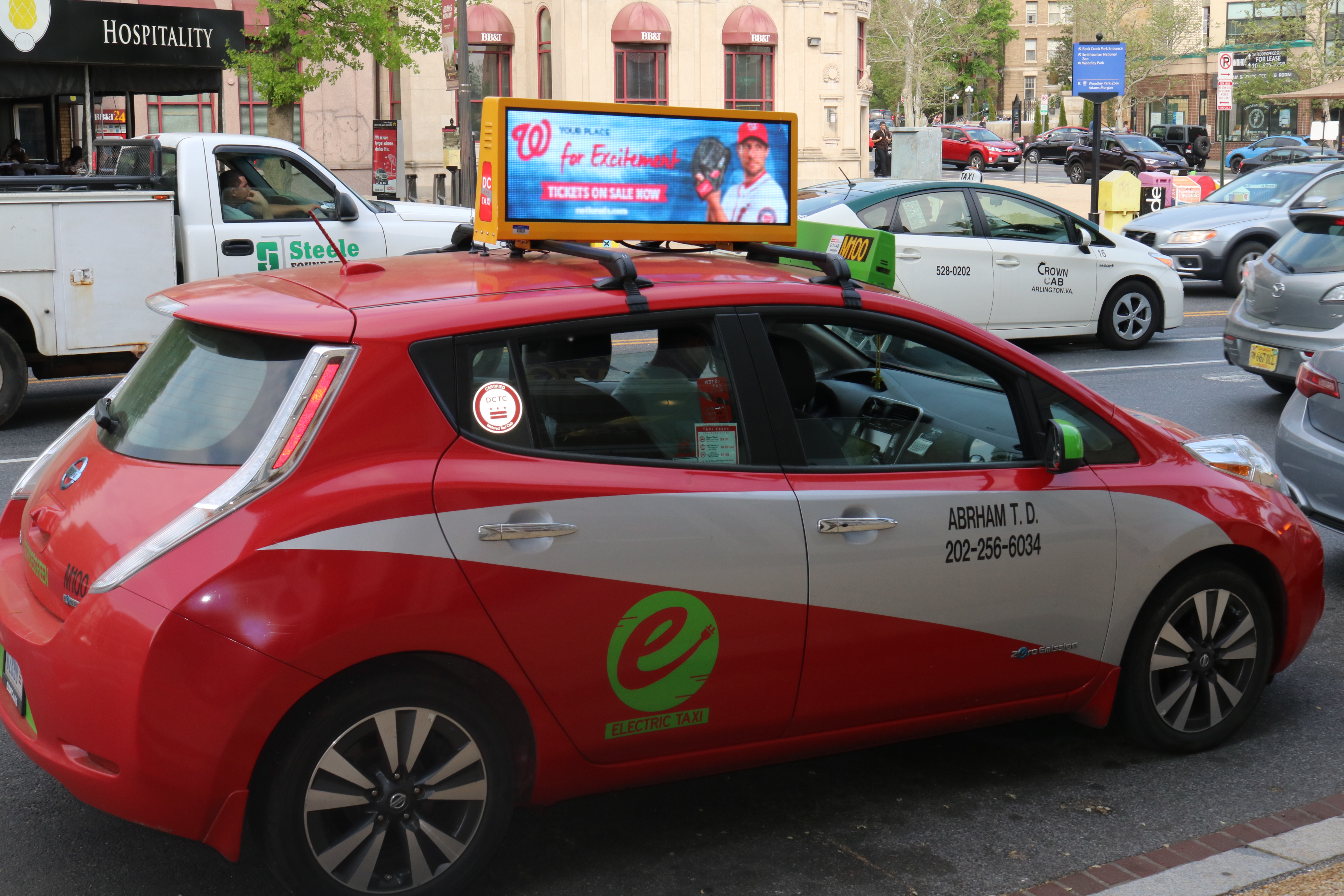 Red taxi with a digital rooftop ad