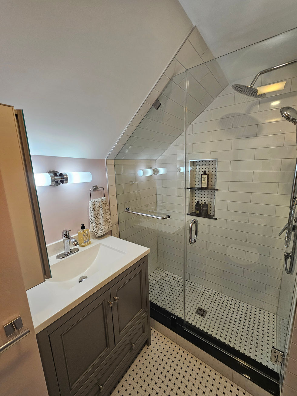 Attic bathroom remodel in Ashmont Square Boston with walk-in shower, frameless glass, subway tile, mosaic floor, and blush walls.