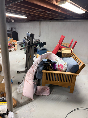 Team loading an old futon into a junk removal truck during a furniture removal job in Milford, Connecticut by Coastal Cleanouts.