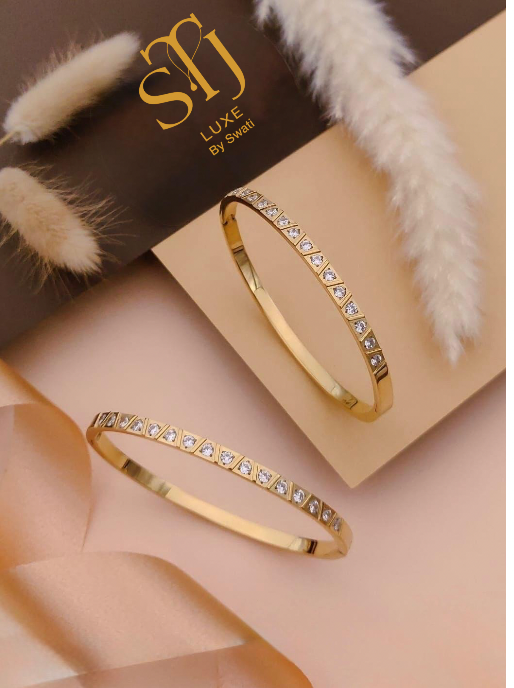 Two gold bangles with square gems, SMJ LUXE branding card