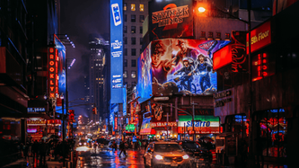 Times Square di notte con maxi schermi luminosi, traffico e luci di New York