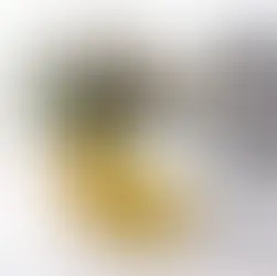 Yellow pot with a smiling face, holding succulent plants. Background features a black-and-white abstract framed print and a pen.