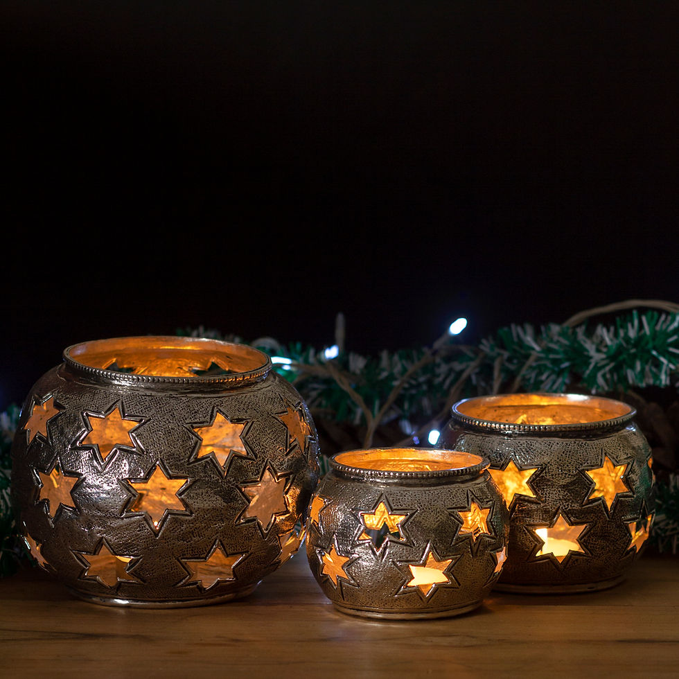 Three star-patterned candle holders glow warmly on a wooden surface, surrounded by green garland and white lights against a dark background. Christmas theme. product Photography, E commerce Photography, Amazon Photoshoot.