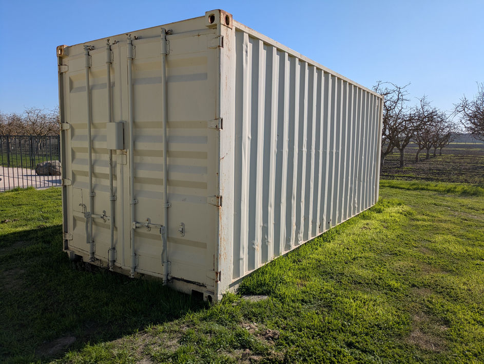 40 foot tan conex shipping container on a grassy field