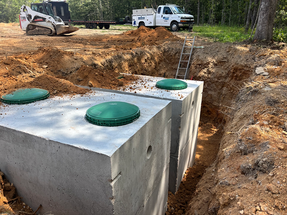 Concrete septic tanks installed in a dirt excavation site trench.