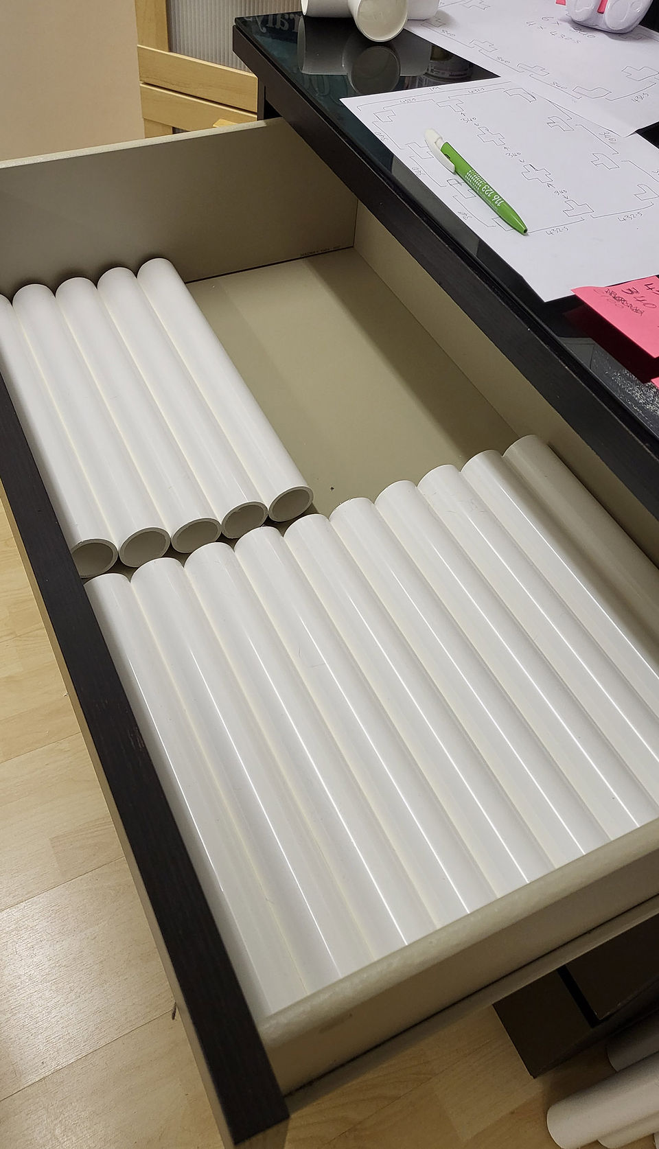Open drawer with white cylindrical organizers