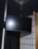 A monitor on a mount within a vocal booth space.