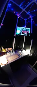 Remote studio with blue ceiling lights, monitor, and desk