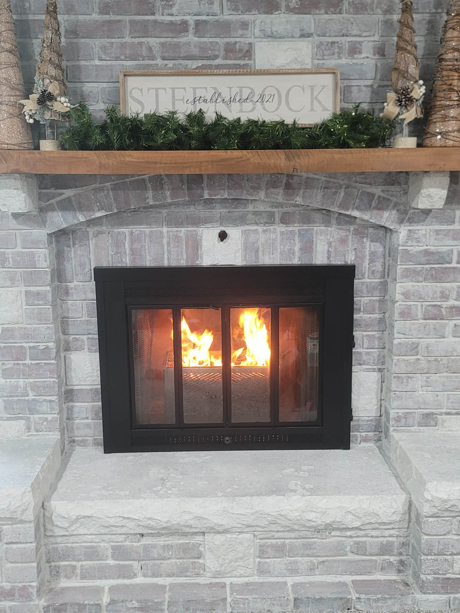 Steel pellet basket inside fireplace actively burning wood pellets