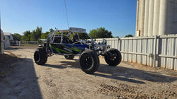 Sand car with paddle tires and Insandity Fab graphics wrap in blue green white and black.
