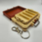Thumbnail: A small, keychain-sized plastic tackle box is shown open, revealing organized compartments holding yellow capsules and assort