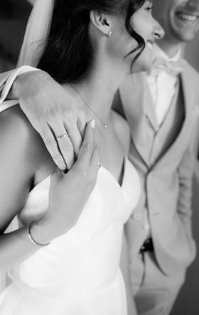 Ein Brautpaar spaziert Arm in Arm. Beide lächeln.