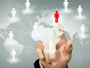 A hand interacting with a digital world map featuring connected human icons, highlighting a red figure to represent offshore staffing. This visual illustrates how to build your global team through Confetti Recruitment’s specialized offshore hiring solutions.